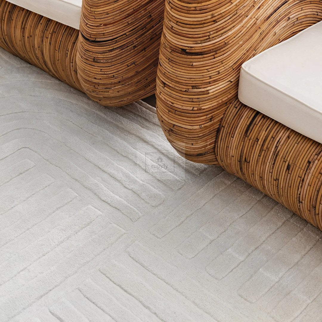 Ivory tone-on-tone carved geometric high-low textured hand-tufted wool rug with rattan furniture