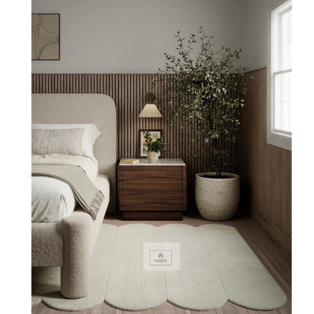 Sage green scalloped edge plush hand-tufted wool rug beside a boucle bed in a modern bedroom