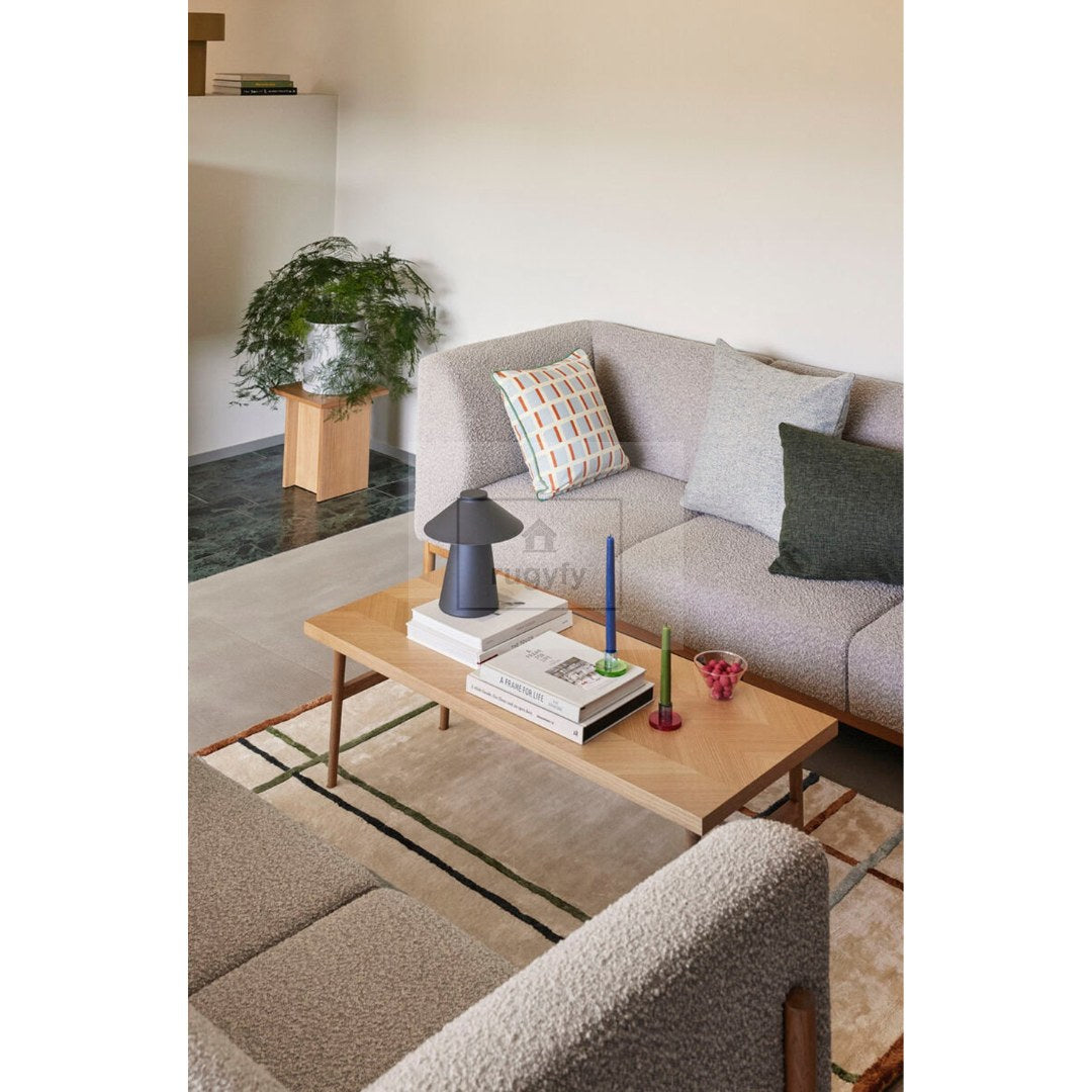Sand beige mid-century modern hand-tufted wool rug with thin black, green and rust lines in a living room